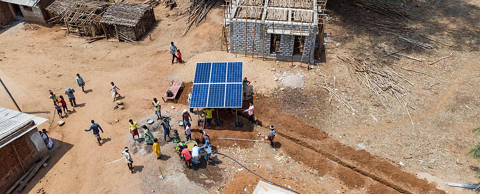 Aerial view of an African village, solar-powered well in the center