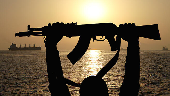 silhouette of machine gunin front of ship