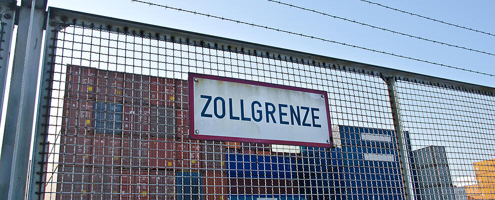 Schild am Zaun, Zollgrenze