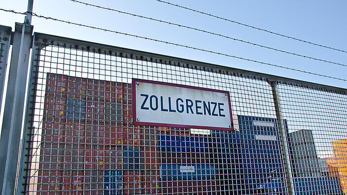 Schild am Zaun, Zollgrenze